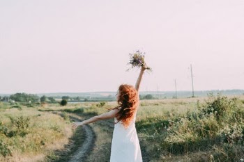 Woman in Dress with a Bouquet of Flowers on the Country Road  · Free Stock Photo