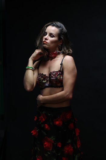 Woman in Floral Dress Standing Near Black Background