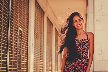 Woman In Floral Halter Dress Leaning On Wall