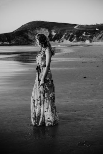 woman in floral long dress standing on seashore