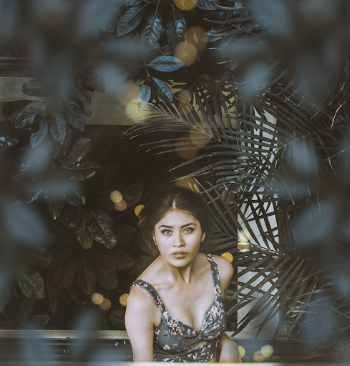 Woman in Floral Top Surrounded by Leaves