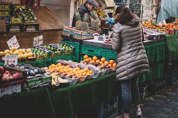 woman in front of fruit stands in market