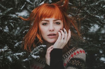woman in front of tree covered snow during daytime