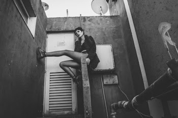 Woman in Fur Coat Sitting on Concrete Handrail