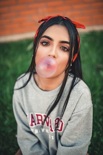 Woman in Gray Aeropostale Sweater Playing With Gum