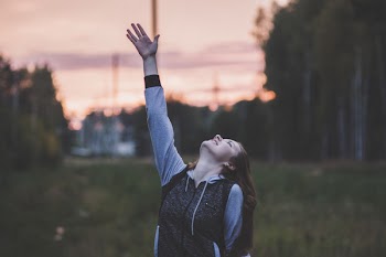 Woman in Gray and Black Zip-up Hoodie Raising Her Right Hand