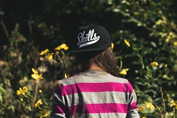 Woman in Gray and Pink Longsleeve Shirt Wearing Black Skill Printed Cap