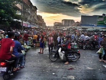 Woman in Gray and Red Jacket Riding White Motor in Crowded Place