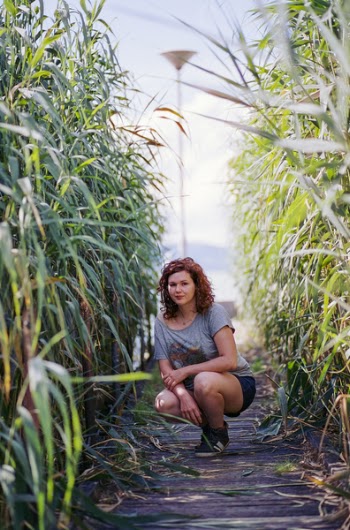 Woman in Gray and Red Scoop Neck T-shirt Seating in Between of Green Plant during Daytime