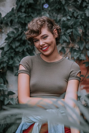 Woman in Gray Blouse Standing in Front Vines