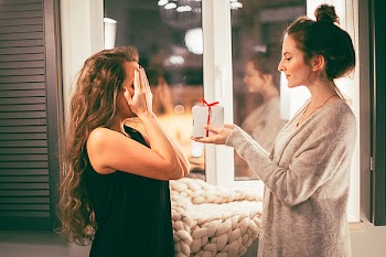 Woman in Gray Cardigan Giving White Gift Box