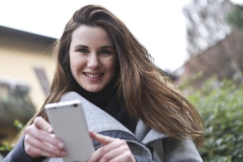 Woman in Gray Coat Holding White Smartphone