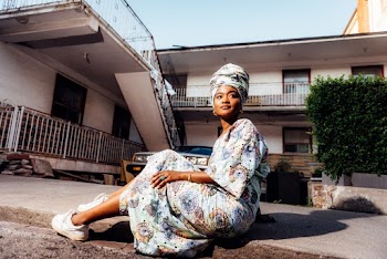 Woman in Gray Dress Sitting on Pavement