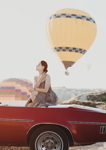 Woman in Gray Dress Sitting on Red Convertible Car