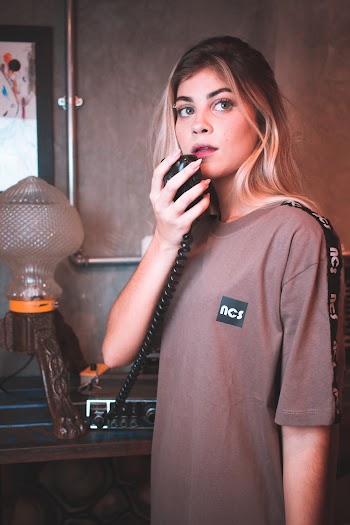 Woman in Gray Long Sleeve Shirt Holding A Black Microphone