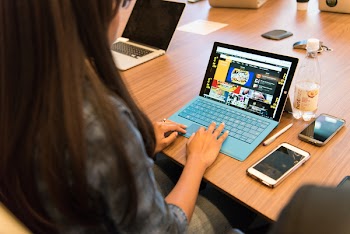 Woman in Gray Long-sleeved Top Using Laptop