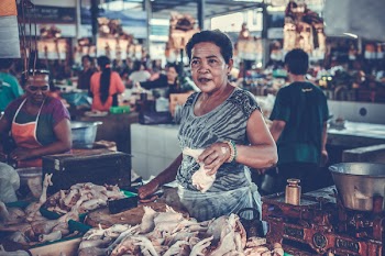 Woman in Gray Shirt Holding a Chicken Piece