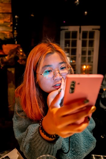 Woman in Gray Sweater Holding Smartphone