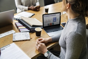 Woman in Gray Sweater Sitting Near Laptop