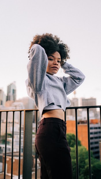 Woman in Gray Sweater Standing Beside Metal Rail