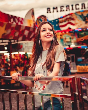 Woman in Gray T-shirt Smiling while Holding Rails