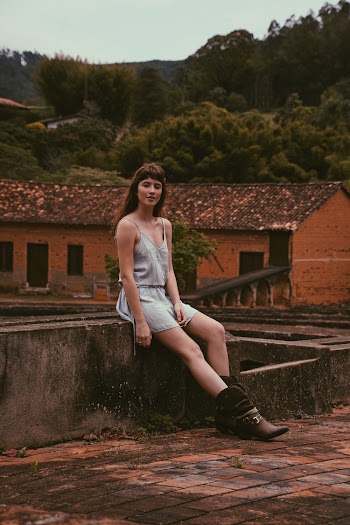 Woman in Gray Tank Dress Sitting on Concrete Fence