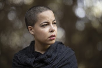 Woman in Gray Top and Shaved Head Looking Away