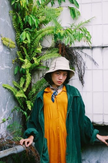 Woman in Green and Orange Jacket Standing Beside Green Plant · Free Stock Photo