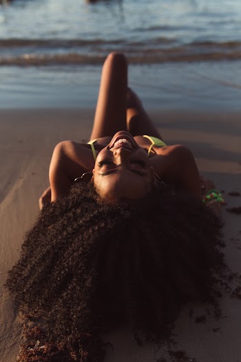 Woman in Green Bikini Lying on the Beach