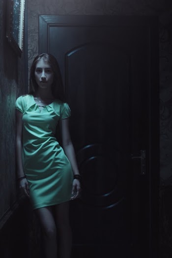 Woman in Green Dress Standing Near Door
