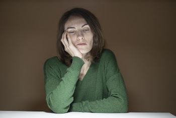 Woman in Green Sweater Holding Her Cheek