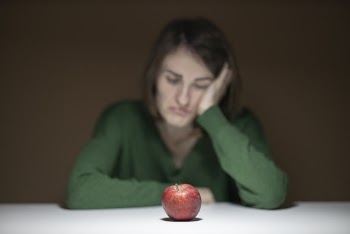 Woman in Green Sweater Sitting in Front of Apple