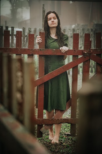 Woman in Green Top Standing By the Fence