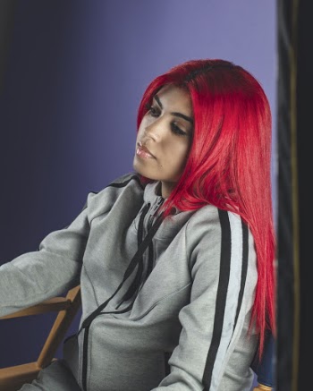 Woman in Grey and Black Jacket Sitting on Brown Chair