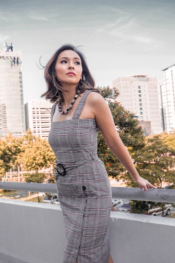 Woman in Grey Checkered Dress Holding Hand Rail