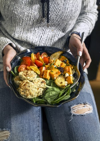 Woman in Grey Long-sleeved Shirt Holding Black Ceramic Plate With Cooked Foods