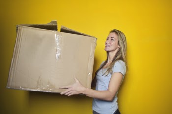 Woman In Grey Shirt Holding Brown Cardboard Box