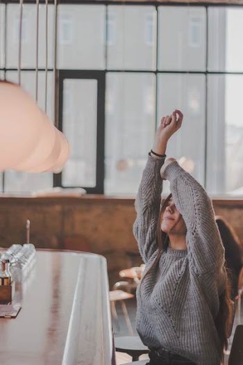 Woman In Grey Sweater Raising Both Of Her Arms
