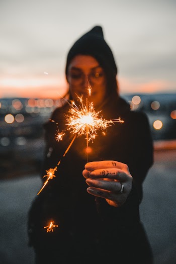 Woman in Hoodie Holding Lighted Sparkler