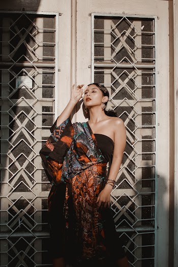 Woman in Multicolored Dress Leaning on Wall