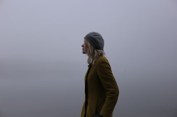 woman in olive-green jacket and gray hat