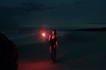woman in one-piece swimsuit holding torch