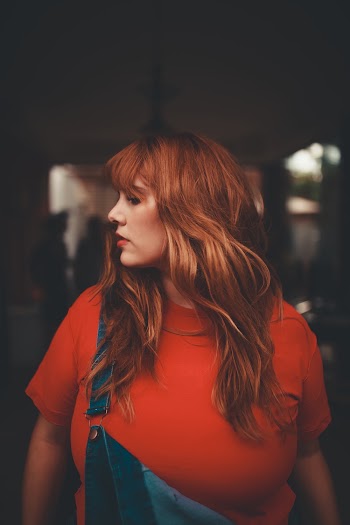 Woman in Orange T Shirt Turning Head to Right