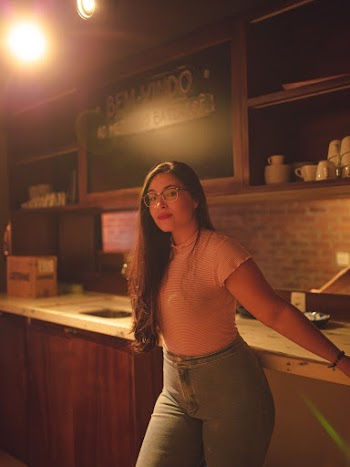 Woman in Pink Crew-neck Top and Blue Jeans Standing Indoors