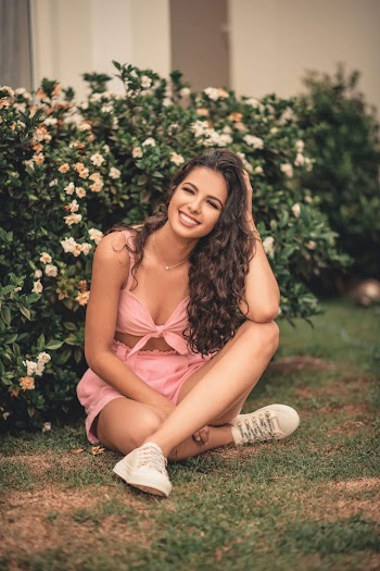 Woman in Pink Crop-top and Short Shorts Sitting on Grass