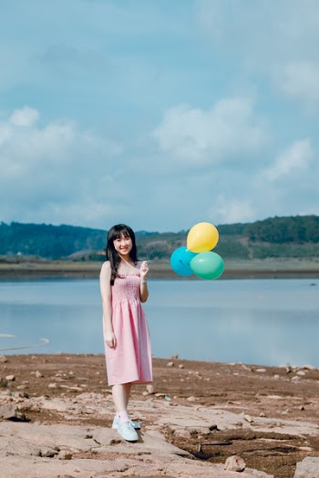 Woman in Pink Dress Holding Balloons