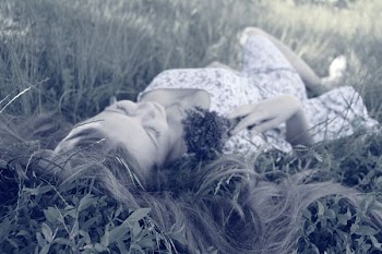 woman in pink dress laying on grass during daytime