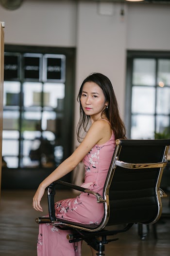 Woman In Pink Floral Cami Dress Sitting On Black Chair