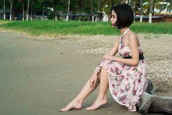 Woman in Pink Floral Halter Dress Seating in Driftwood