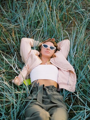 Woman in Pink Long Sleeve Shirt Lying on Green Grass Field · Free Stock Photo